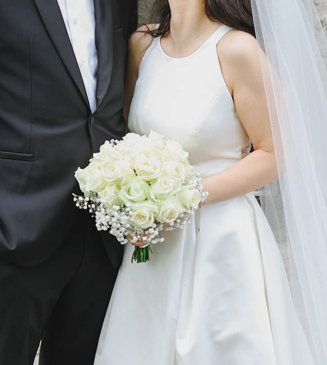 Brautpaar mit weißem Rosenstrauß