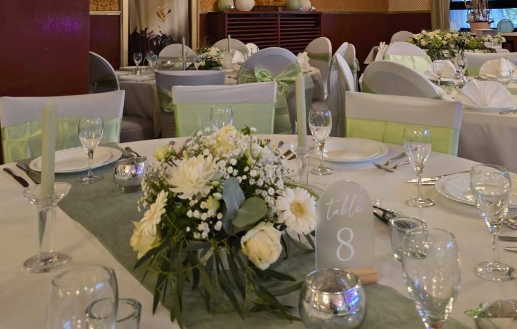 Hochzeitstisch-Dekoration mit weißen Blumen